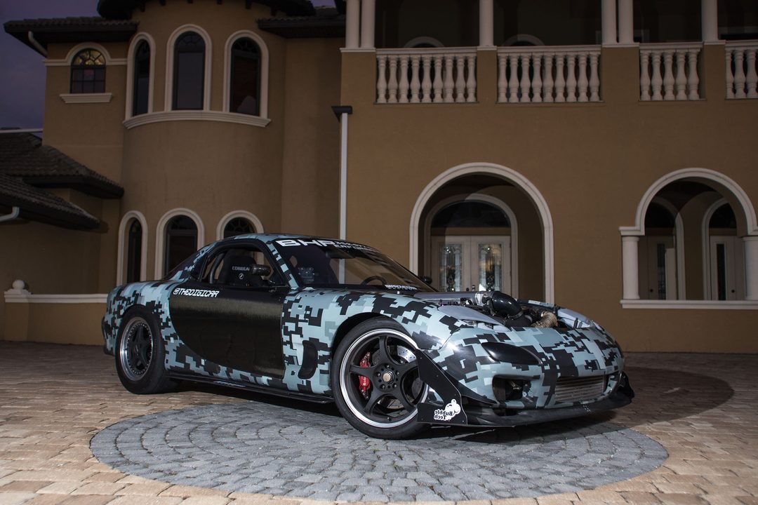 Grey digicamo RX-7 with exposed LS3 turbo piping, parked at night